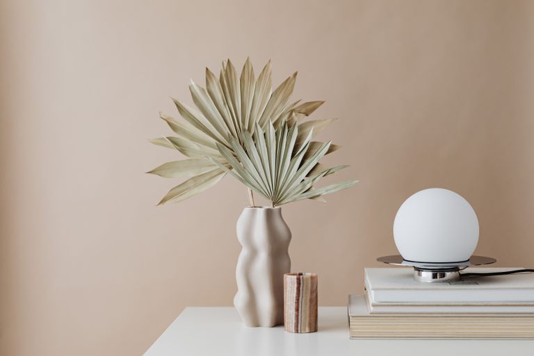 Elegant minimalist interior featuring a dried palm arrangement and modern decor elements.
